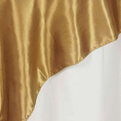 Gold satin fabric draped elegantly against a white background.