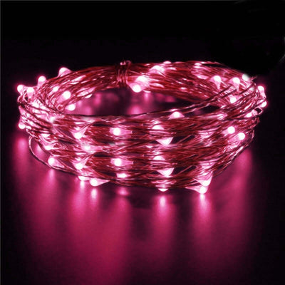 Pink LED fairy lights on a wire strand against a dark background.