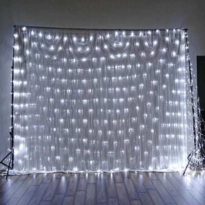 White draped backdrop with fairy lights for events and photography.