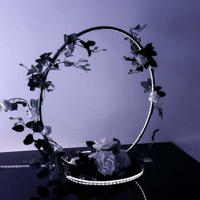 LED floral display with white roses and greenery in a circular design.