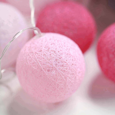Pink decorative string light balls in soft focus.