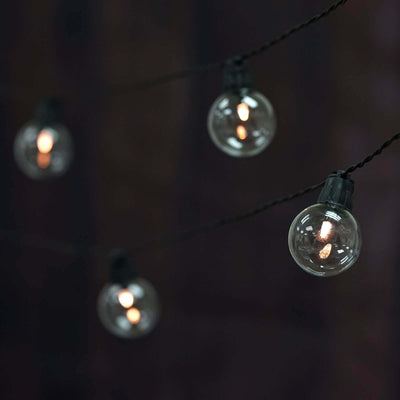 String of vintage glass globe lights hanging on a dark background.