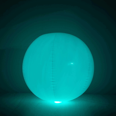 Glow-in-the-dark inflatable beach ball in vibrant teal color.