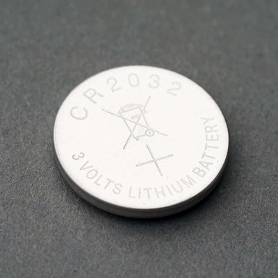 CR2032 3 Volts Lithium Battery on a gray background.