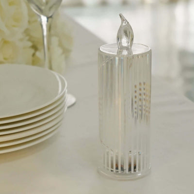 Elegant glass candle holder with ribbed design, set on a table with plates.