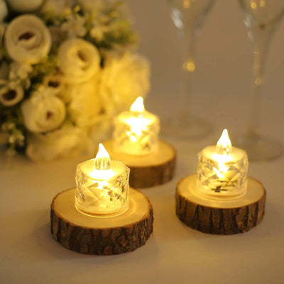 LED tealight candles on wooden slices with flowers in the background.