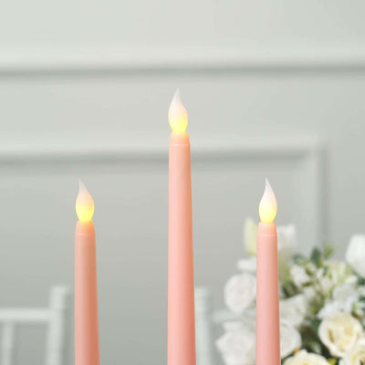 Pink LED taper candles with flame-like tips on a soft background.