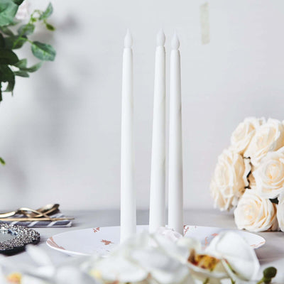 Three white candles on a decorative plate with flowers in the background.