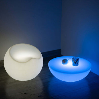 Modern illuminated table lamp in unique shapes, glowing softly in blue light.