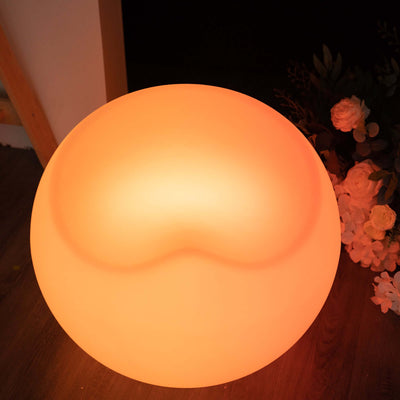 Round glowing lamp with a soft orange hue and smooth surface.