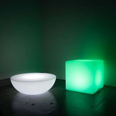 Glowing green cube and white bowl light fixtures in a dark setting.