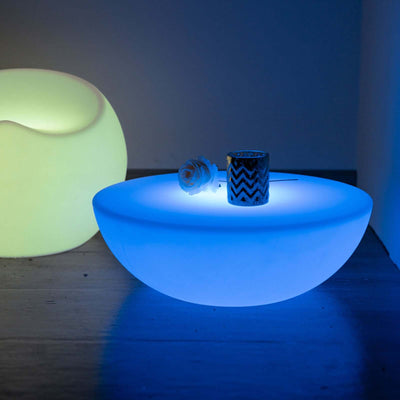 Illuminated decorative bowl with candle holder on a stylish surface.