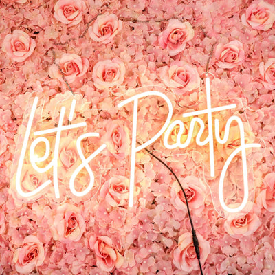 Neon "Let's Party" sign against a pink floral backdrop.