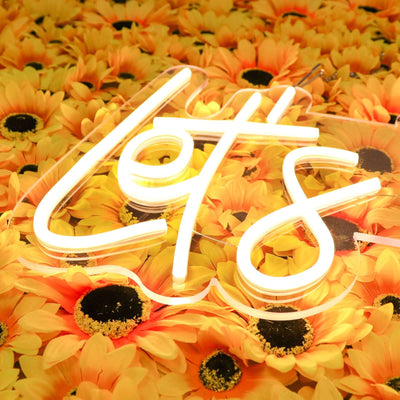 Neon "Let's" sign on a vibrant sunflower background.