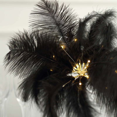 Black feather centerpiece with lights for elegant decoration.