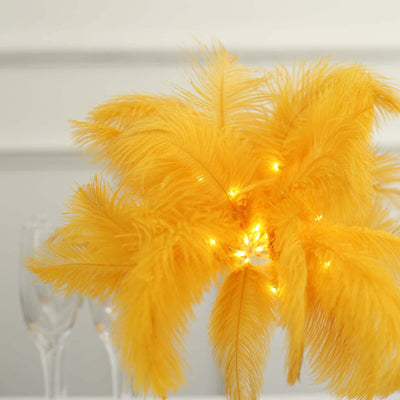 Yellow feather centerpiece with lights for festive decor.