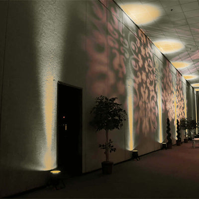 Decorative wall lighting casting intricate patterns in a dimly lit interior space.