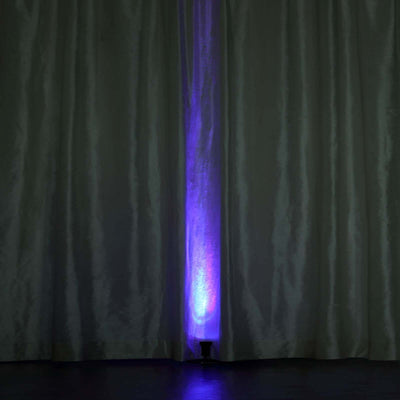 Purple LED light shining through white curtains.