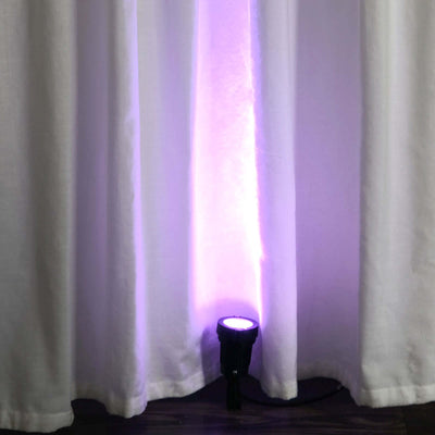 Purple LED spotlight illuminating white curtains in a staged setup.