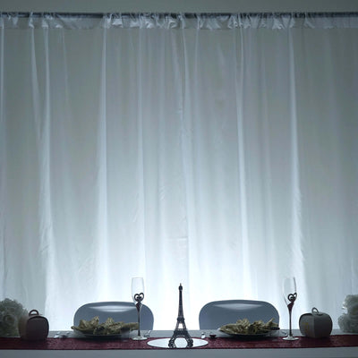 Elegant table setting with Eiffel Tower centerpiece and white drapery backdrop.