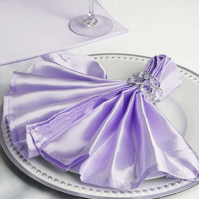 Lavender satin napkin elegantly arranged on a plate with a decorative ring.