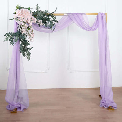 Wedding arch with purple drapery and floral accents.