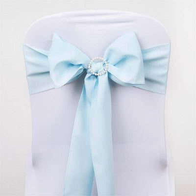 Light blue satin chair sash with pearl embellishment on a white chair.