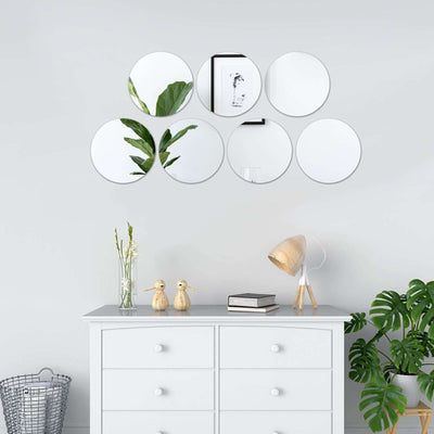 Decorative wall mirrors arranged above a stylish dresser with plants and decor.