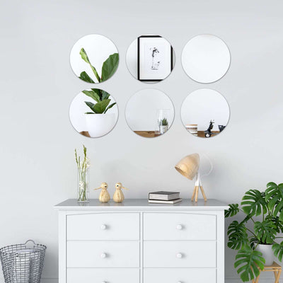 Decorative round mirrors arranged above a modern dresser in a stylish living room.