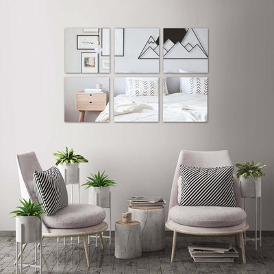 Modern living room with stylish chairs, plants, and mountain-themed wall art.