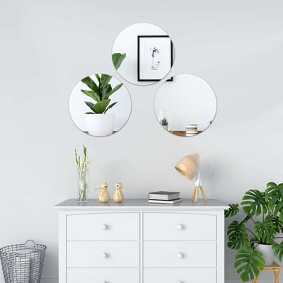 Decorative mirrors on a gray dresser with plants and decor in a stylish interior setting.