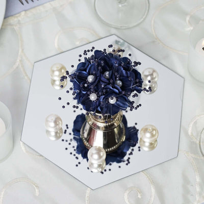 Navy flower arrangement with pearls on a mirrored hexagonal base.