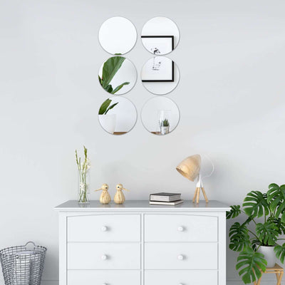 Decorative wall mirrors above a stylish dresser with plants and decor items.