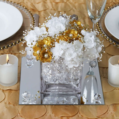 Elegant floral arrangement in a crystal vase with gold and white flowers.