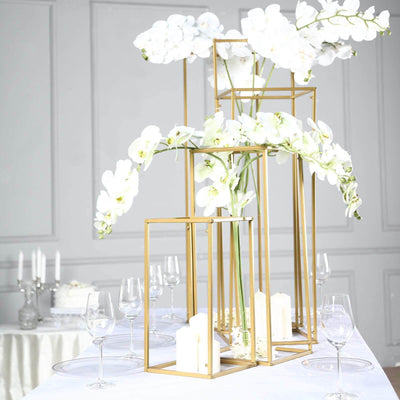 Elegant gold and white orchid centerpiece on a dining table.