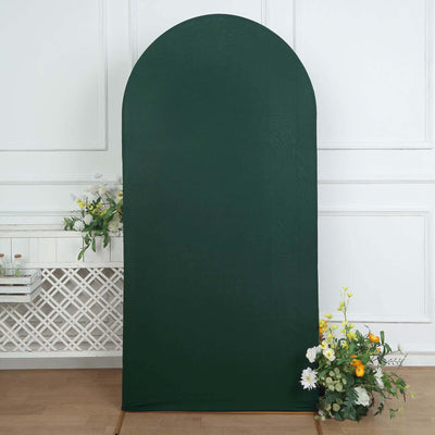 Green arch backdrop for photography with floral arrangement at the base.