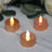 LED tealight candles in rose gold holders, creating a warm ambiance.