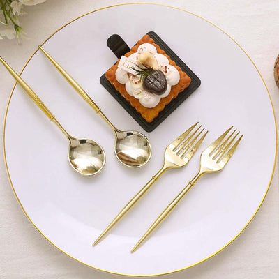 Elegant gold cutlery set beside a gourmet dessert on a white plate.