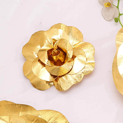 Gold flower decoration on a plain background.
