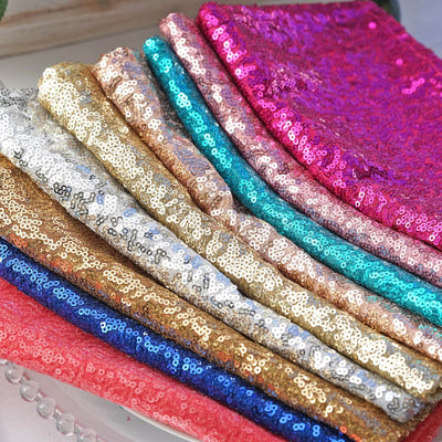 Colorful sequin fabric swatches in various shades stacked neatly.
