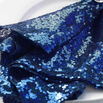 Navy blue sequin fabric draped elegantly on a white plate.