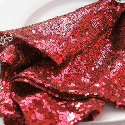 Red sequin fabric draped elegantly on a plate.