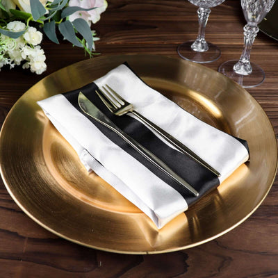 Elegant table setting with a gold charger plate, napkin, and cutlery.