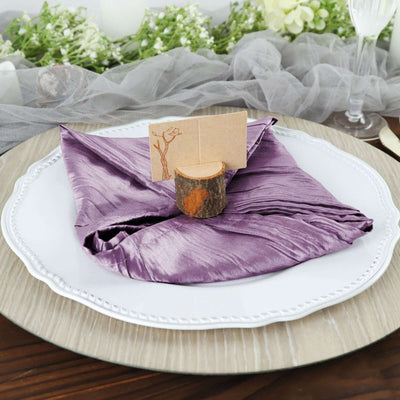 Purple satin napkin elegantly arranged on a white plate with a wooden placeholder.