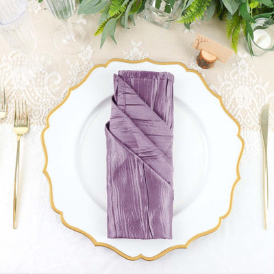 Purple satin napkin elegantly folded on a decorative plate.