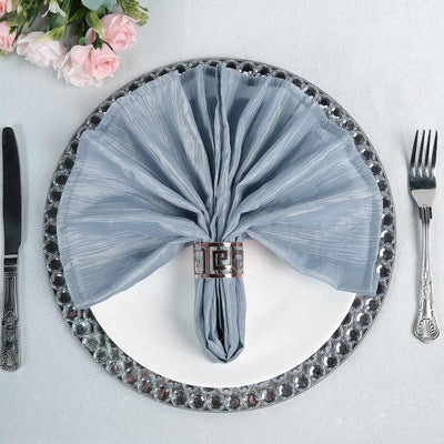 Elegant blue napkin elegantly folded on a decorative plate.