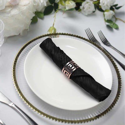 Elegant black napkin with a decorative holder on a fine dining plate.