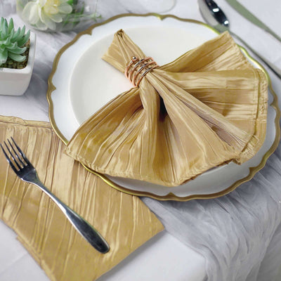Gold pleated napkin with ring on elegant plate, fork beside, styled table setting.