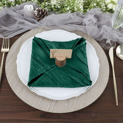 Elegant green napkin folded on a decorative plate with a rustic place card.