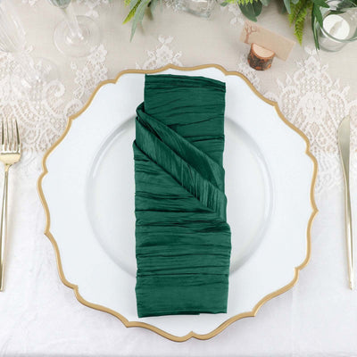 Green pleated napkin elegantly arranged on a decorative plate.